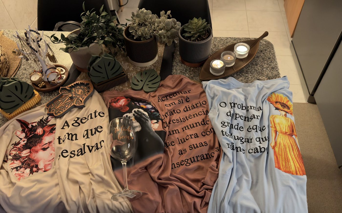 T-shirts estampadas em DTF sobre a bancada da oficina.